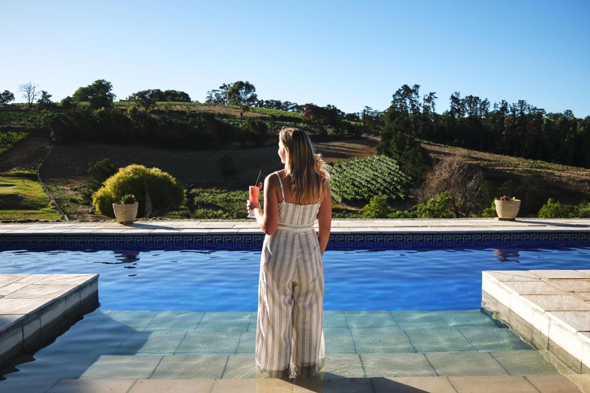Alluvia Boutique Winery & Luxury Accommodation Stellenbosch Bilik gambar A woman standing by a pool